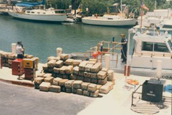 USCG at dock with pails of marijana stacked 4 feet high