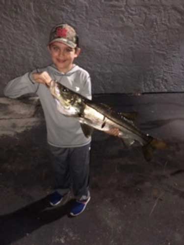 boy holding a huge snook fish