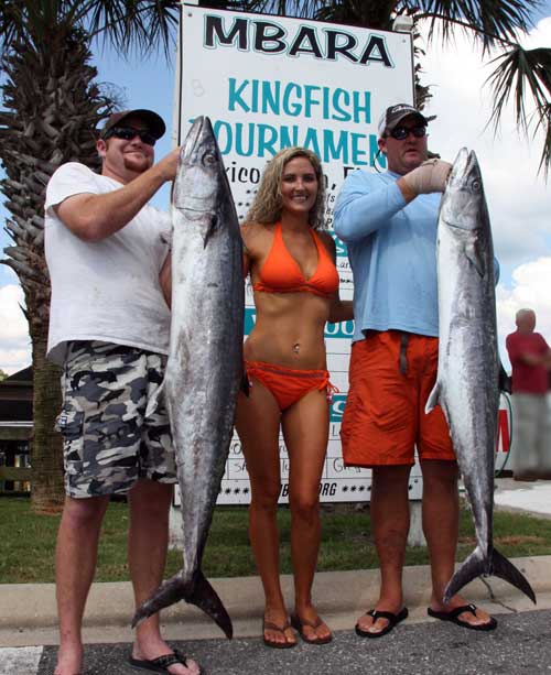 2 men holding the Kingfish tournament winning fish with a girl in orange bathing suit