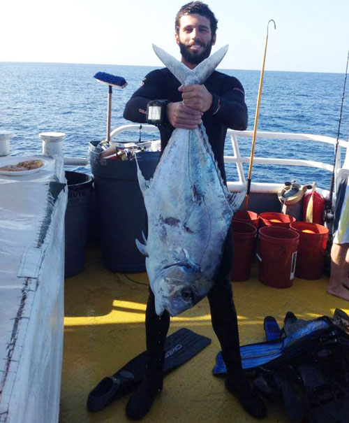 Man in wetsuit holding huge African Pompano