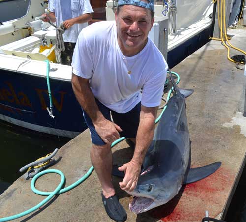 Man standing above his Shortfin Mako Shark