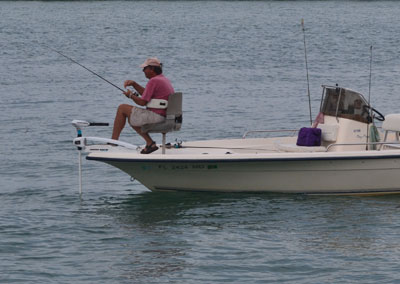 man on a boat seat fishing from a boat