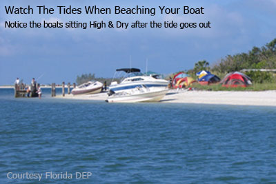 Boats sitting out of the water on the beach with tents in the background