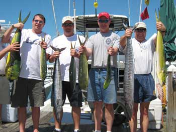 3 men holding dolphins and whaoos on a dock in key west