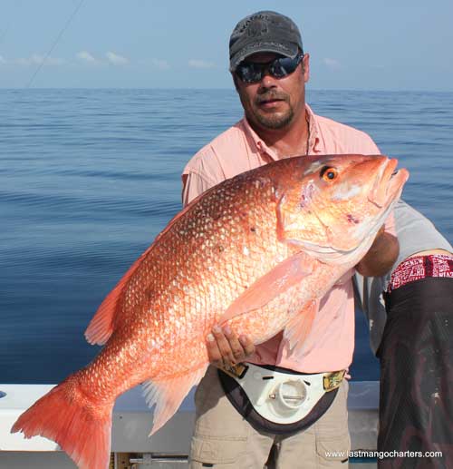 Man holding a huge Red Snapper on a boat off Fort Pierce