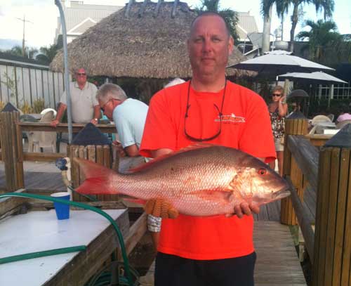 Mutton Snapper held by man on dock