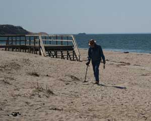Person with metal detector on beach