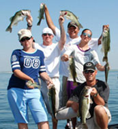 Man holding a bass with his fishing pole