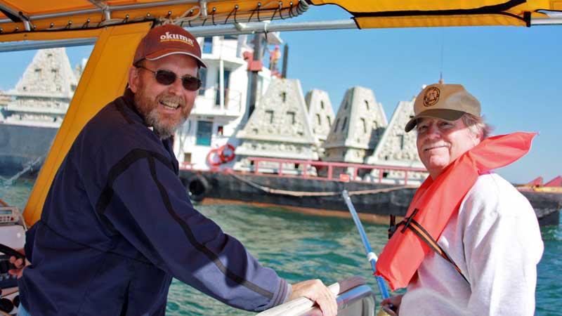 Bob Cox and Bill Horn of FWC on a boat with reef modules on a barge in the background