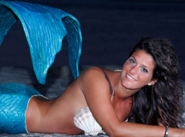 miss mermaid laying on sand with big smile