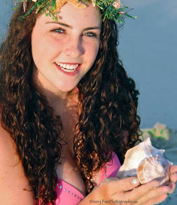 A closeup face shot of miss march mermaid holding a sea shell