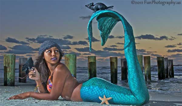 Miss Halloween mermaid looks up at the rat on her tail