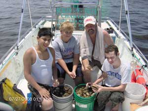 Group of boys with scallops in 5 gallon buckets on a boat